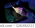 Male hands are using calculator on mobile phone and laptop keyboard. 126392211