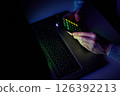 Male hands are using calculator on mobile phone and laptop keyboard. 126392213