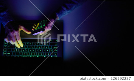 Male hands are using calculator on mobile phone and laptop keyboard. 126392227