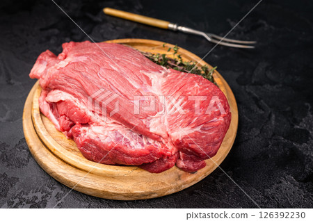 Raw Silverside Round beef meat piece , fresh bottom round on wooden board. black background. Top view Raw Silverside Round beef meat piece , fresh bottom round on wooden board. black background. Top view 126392230