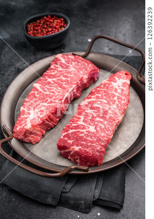 Premium denver, chuck eye steak, beautifully presented, ready for seasoning. A versatile cut ideal for barbecue enthusiasts and steak lovers alike. black background. top view 126392239
