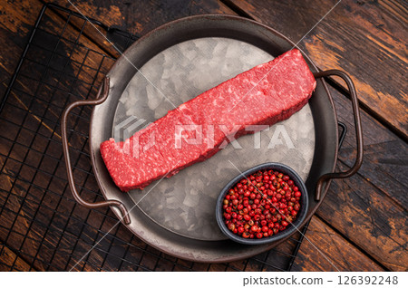 High quality marbled wagyu beef steak, ready to be transformed into a gourmet masterpiece. A delicious choice for any meat lover's palate. wooden background. top view High quality marbled wagyu beef steak, ready to be transformed into a gourmet masterpiece. A delicious choice for any meat lover's palate. wooden background. top view 126392248