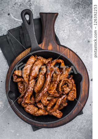 Delicious glazed teriyaki beef in a skillet. grey background. top view 126392253