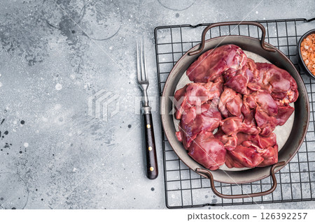 Raw poultry liver, chicken offals beautifully displayed, ready for seasoning. A nutritious ingredient ideal for gourmet dishes and traditional recipes. grey background. top view Raw poultry liver, chicken offals beautifully displayed, ready for seasoning. A nutritious ingredient ideal for gourmet dishes and traditional recipes. grey background. top view 126392257