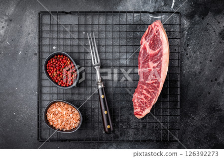 Raw beef picanha steak, featuring a thick layer of fat that adds flavor during cooking. black background. top view Raw beef picanha steak, featuring a thick layer of fat that adds flavor during cooking. black background. top view 126392273