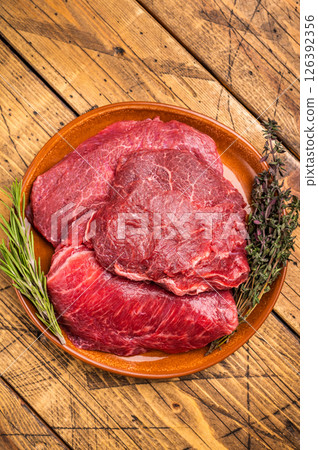 Traditional German beef cheeks, raw meat in plate. wooden background. top view 126392356