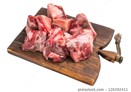 Raw diced Beef meat with bones for stew or goulash on wooden board isolated on white background. top view Raw diced Beef meat with bones for stew or goulash on wooden board isolated on white background. top view 126392411