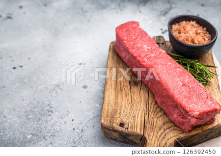 Juicy raw Kobe style beef, renowned for its exceptional flavor and tenderness. Perfect for preparing mouthwatering steaks or sashimi. grey background. top view 126392450