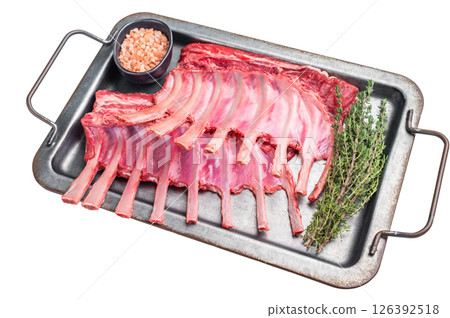 Raw mutton meat for chops steaks, uncooked rack of lamb on steel tray with herbs isolated on white background. top view Raw mutton meat for chops steaks, uncooked rack of lamb on steel tray with herbs isolated on white background. top view 126392518