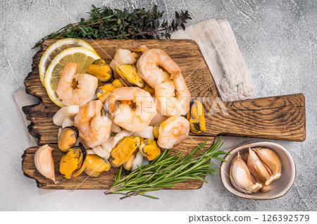 Fresh Seafood cocktail, raw Mix with Mussels, Clams, Prawns, Shrimps and squid on wooden board. white background. top view Fresh Seafood cocktail, raw Mix with Mussels, Clams, Prawns, Shrimps and squid on wooden board. white background. top view 126392579