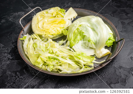 Fresh raw iceberg lettuce salad cut leaves. black background. top view 126392581