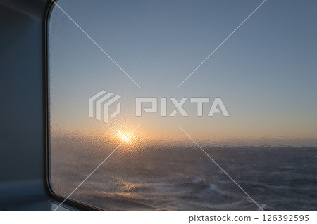 [Tokyo Kyushu Ferry bound for Mayu Shinmoji Port: Sunrise over the Pacific Ocean during a rough storm] 126392595