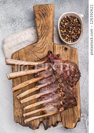 Grilled Rack of lamb, mutton meat chop steaks on wooden board. grey background. top view 126392621