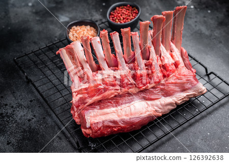 Raw rack of lamb, fresh mutton meat for chops cutlets. black background. top view Raw rack of lamb, fresh mutton meat for chops cutlets. black background. top view 126392638