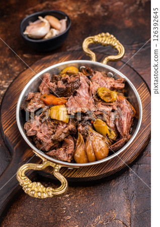 Slow cooked Beef Cheek, Braised meat with vegetables in a skillet. brown background. top view Slow cooked Beef Cheek, Braised meat with vegetables in a skillet. brown background. top view 126392645
