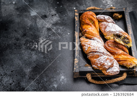 Roll pastry with Pistachios and chocolate, Danish Puff pastry. black background. top view 126392684