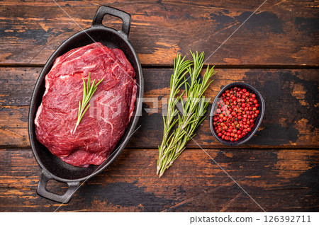 Ready for cooking beef cheeks, raw meat in skillet. wooden background. top view 126392711