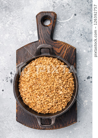 Raw buckwheat flakes in a skillet. grey background. top view Raw buckwheat flakes in a skillet. grey background. top view 126392757