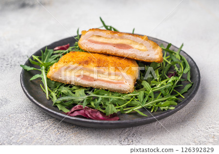 Fried Cordon bleu escalopes with salad on plate. white background. top view 126392829