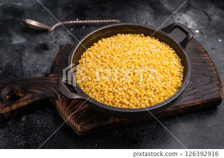 Ptitim pasta, Israeli couscous in a skillet. black background. top view Ptitim pasta, Israeli couscous in a skillet. black background. top view 126392916
