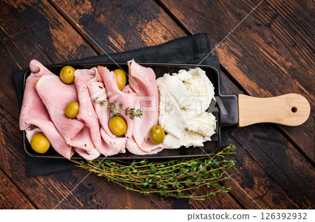 Italian antipasto with Sliced Prosciutto Cotto ham, green olives and mozzarella. wooden background. top view 126392932