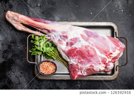 Uncooked whole mutton leg, raw organic lamb meat. black background. top view Uncooked whole mutton leg, raw organic lamb meat. black background. top view 126392938