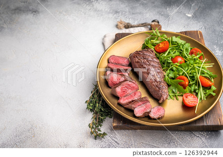 Grill Goat steak, roasted tenderloin fillet meat with salad. grey background. top view 126392944
