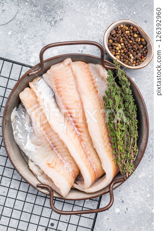 Raw Hake fish fillet in steel tray with herbs. grey background. top view 126392960