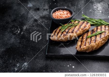 Grilled lula kebabs, perfect for an authentic Middle Eastern feast. black background. top view Grilled lula kebabs, perfect for an authentic Middle Eastern feast. black background. top view 126393031