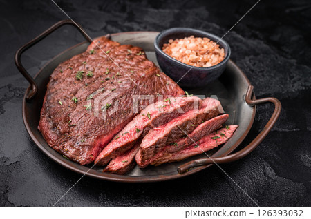Succulent grilled top sirloin steak, cooked to perfection and drizzled with a rich sauce for an unforgettable dining experience. black background. top view Succulent grilled top sirloin steak, cooked to perfection and drizzled with a rich sauce for an unforgettable dining experience. black background. top view 126393032