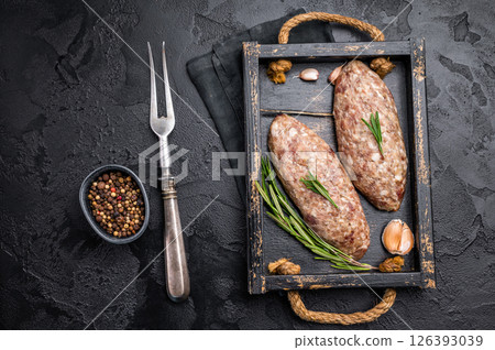 Raw kebabs or kabaps on wooden tray, beautifully arranged and ready to be cooked for a delicious outdoor feast. black background. top view 126393039