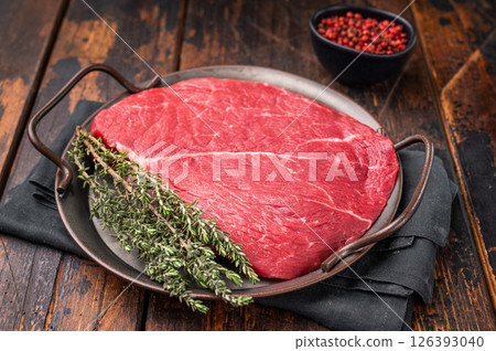Premium raw rump or top sirloin beef steak on a tray, ready to be seasoned and grilled to perfection. wooden background. top view 126393040