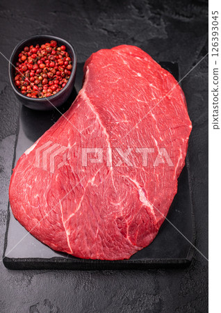 Juicy raw top sirloin cut, highlighting its marbling and freshness, perfect for your next barbecue or dinner party. black background. top view 126393045