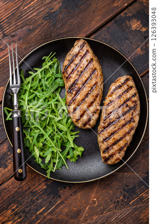 A platter of flavorful bbq roast kofta kebabs, beautifully garnished with vegetables and ready to delight your taste buds. wooden background. top view A platter of flavorful bbq roast kofta kebabs, beautifully garnished with vegetables and ready to delight your taste buds. wooden background. top view 126393048