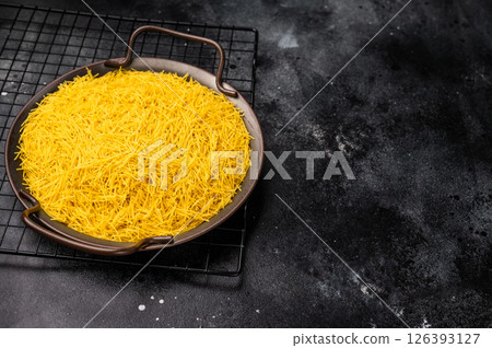 Raw Vermicelli, uncooked pasta in a tray. black background. top view 126393127