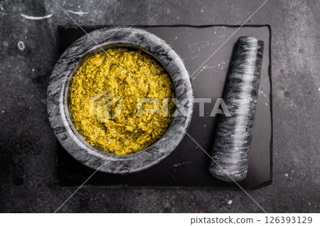 Iitalian spread sauce pesto with green basil in bowl. black background. top view Iitalian spread sauce pesto with green basil in bowl. black background. top view 126393129
