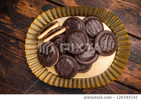 Steel plate with Jaffa Cookies covered with chocolate and filled with jam. Wooden background. top view 126393142