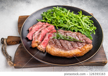 Tender grilled striploin New York steak paired with fresh vegetables, the ultimate comfort food for any occasion. white background. top view 126393163