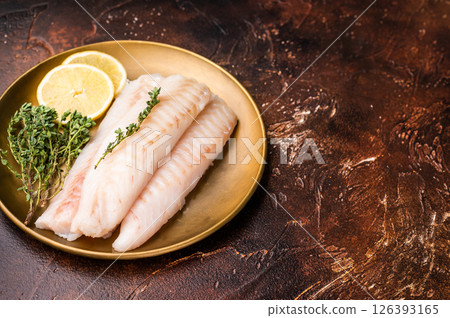 Raw cod loin pieces, whitefish fillets without skin on plate with herbs. brown background. top view 126393165