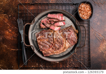 BBQ fried and sliced Chuck eye roll steak in a steel tray, prime beef meat. brown background. top view BBQ fried and sliced Chuck eye roll steak in a steel tray, prime beef meat. brown background. top view 126393179