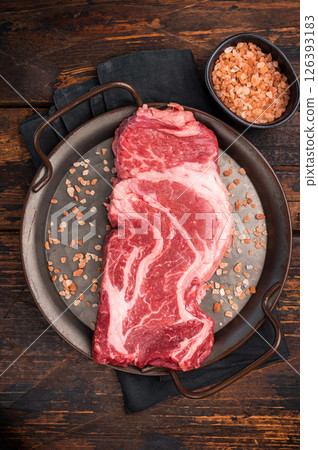 Prime Raw Chuck eye roll steak, fresh beef meat in steel tray. wooden background. top view 126393183