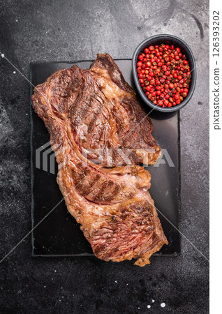 Roasted Chuck eye roll steak, marbled beef meat on a board. black background. top view Roasted Chuck eye roll steak, marbled beef meat on a board. black background. top view 126393202