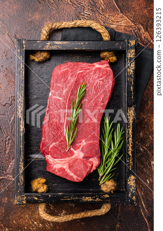 Fresh butchered Raw top sirloin beef steak with rosemary. brown background. top view Fresh butchered Raw top sirloin beef steak with rosemary. brown background. top view 126393215