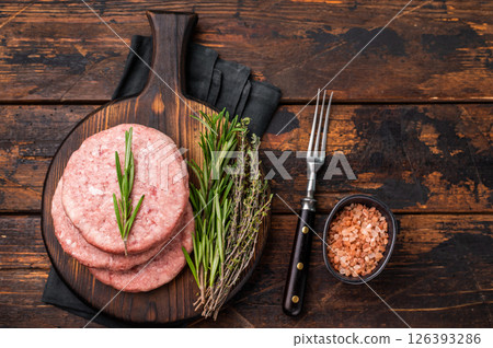 Uncooked beef and pork meat patty on a wooden board, inviting you to create your favorite gourmet burger recipes. wooden background. top view Uncooked beef and pork meat patty on a wooden board, inviting you to create your favorite gourmet burger recipes. wooden background. top view 126393286