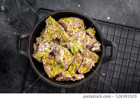Oriental Halva with pistachio in a skillet. Natural vegan sweets. black background. top view. Oriental Halva with pistachio in a skillet. Natural vegan sweets. black background. top view. 126393320
