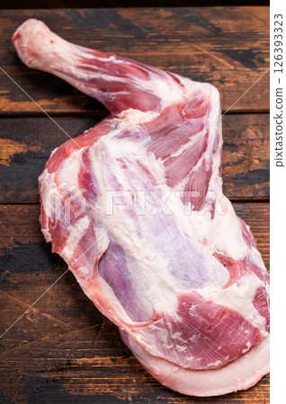 Juicy raw goat shoulder cut, showcasing its vibrant color and texture, perfect for grilling or braising. wooden background. top view Juicy raw goat shoulder cut, showcasing its vibrant color and texture, perfect for grilling or braising. wooden background. top view 126393323