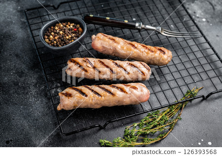 BBQ Grilled beef and pork sausages on steel rack. black background. top view BBQ Grilled beef and pork sausages on steel rack. black background. top view 126393568