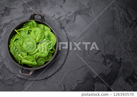 Crisp and lush fresh spinach ready for your favorite recipes, a versatile superfood for every meal. black background. top view Crisp and lush fresh spinach ready for your favorite recipes, a versatile superfood for every meal. black background. top view 126393570