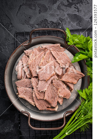 Boiled sliced beef meat in a steel tray. black background. top view 126393577