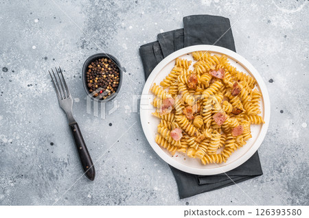 Carbonara pasta topped with crispy bacon bits and parmesan cheese in a plate. Gray background. Top view Carbonara pasta topped with crispy bacon bits and parmesan cheese in a plate. Gray background. Top view 126393580